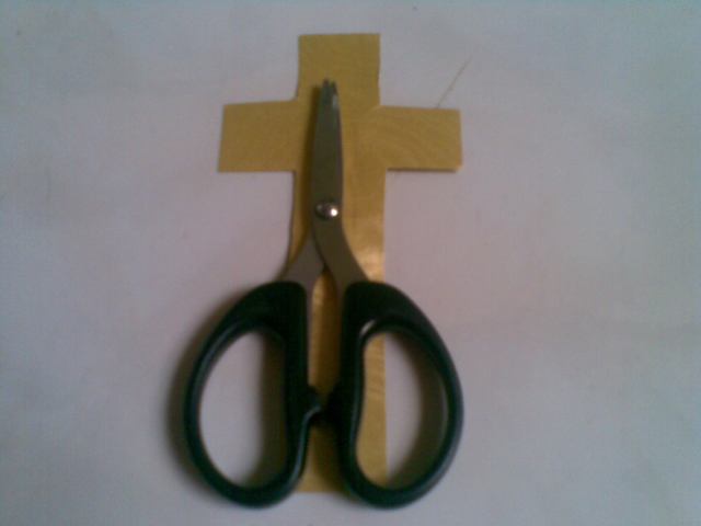 sematkan tanda salib di belakang gunting, jelaskan saat menggunting ikatan tali. 