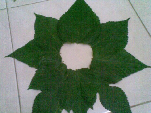 Susun daun bertumpuk melingkar dengan menyisakan area lobang tengah, untuk menjiplak bentuk bunga