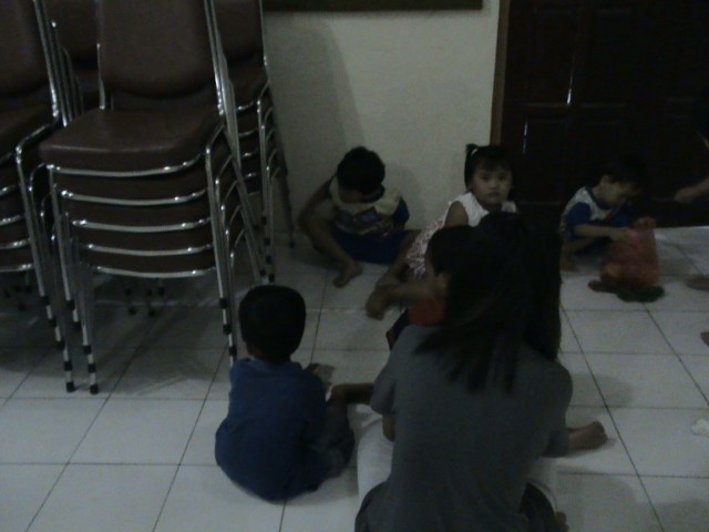 ANAK BALITA BERSIAP MERAYAP DI BAWAH LORONG KURSI GEREJA