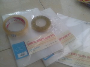 Siapakan esolasi bening, pita emas ( saya sarankan warna emas atau perak yang bisa masuk ke semua warna yang dipilih anak-anak nanti ( warna goresan cryon- mereka) Siapkan sampul buku plastik siap pakai, gunting sampul buku plastik tersebut menjadi dua