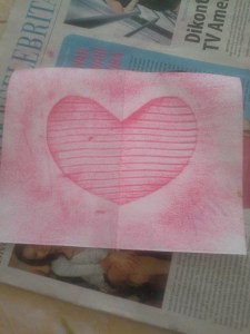 Dengan hati-hati balikkan daun di bawah dan kertas di atas. Pastikan posisinya tetap di as, jangan bergeser. Gores dengan cryon searah dengan serat daun, jangan berlawanan serat.